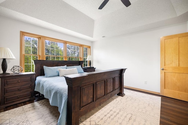 11050 Sweetwater Path, Woodbury, MN 55129 - bedroom featuring a textured ceiling, multiple windows, wood finished floors, and a raised ceiling