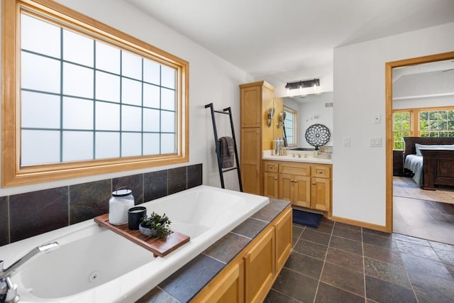 11050 Sweetwater Path, Woodbury, MN 55129 - bathroom with a tub with jets, vanity, ensuite bathroom, and baseboards