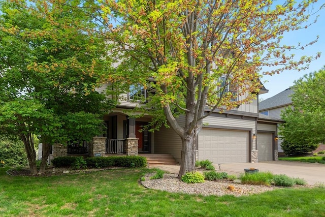 11050 Sweetwater Path, Woodbury, MN 55129 - obstructed view of property with stone siding, a porch, an attached garage, concrete driveway, and a front yard