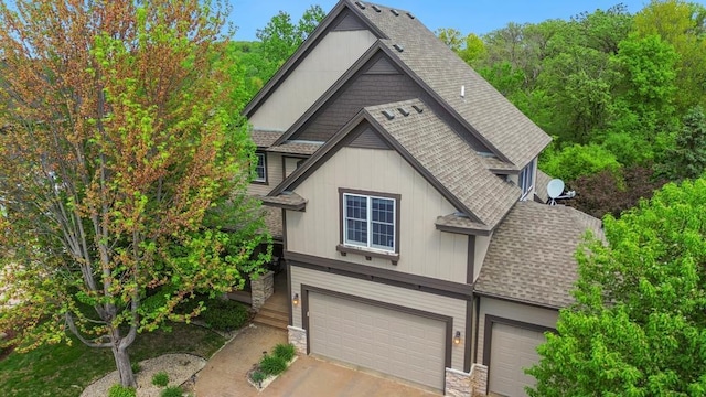 11050 Sweetwater Path, Woodbury, MN 55129 - view of front of property featuring roof with shingles, an attached garage, stone siding, and driveway