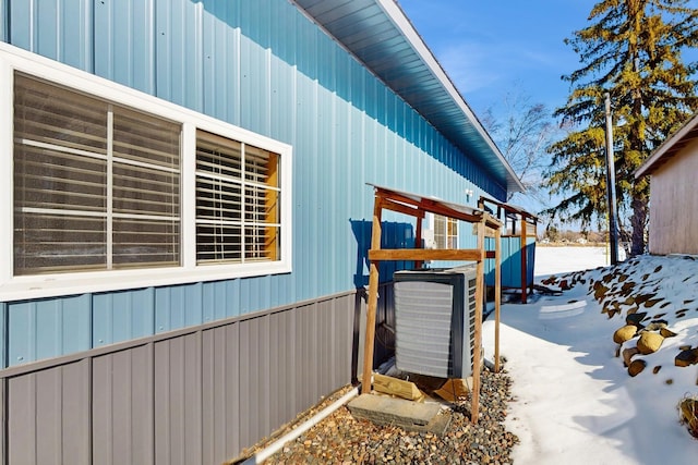 view of side of home featuring board and batten siding and central AC