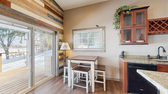 kitchen featuring a sink, glass insert cabinets, black dishwasher, and wood finished floors