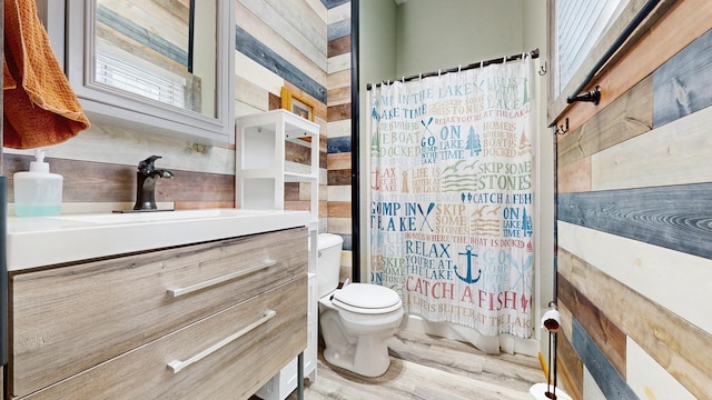 bathroom featuring toilet, wood finished floors, and vanity