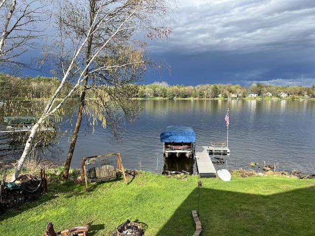 dock area with a lawn and a water view