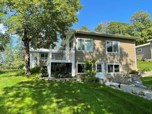 rear view of house with a lawn and a wooden deck