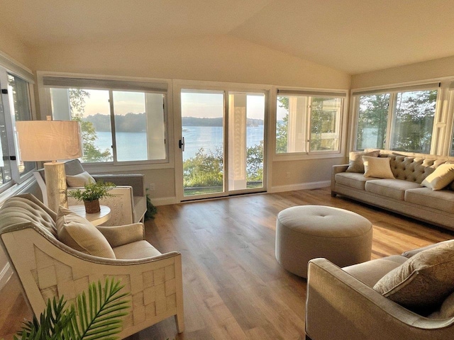 sunroom with a wealth of natural light, a water view, and vaulted ceiling