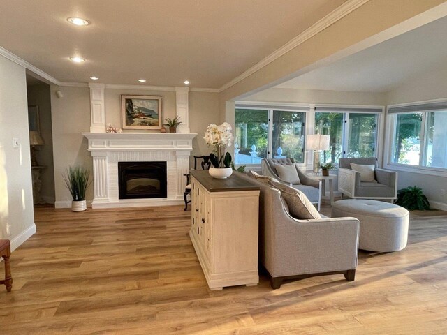 living room with light wood finished floors, a fireplace, and baseboards