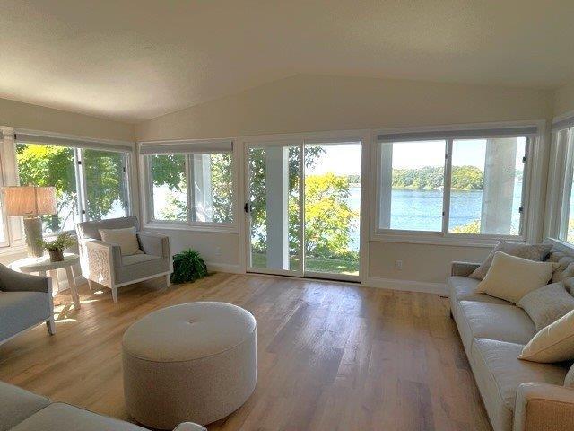 sunroom featuring lofted ceiling and a water view