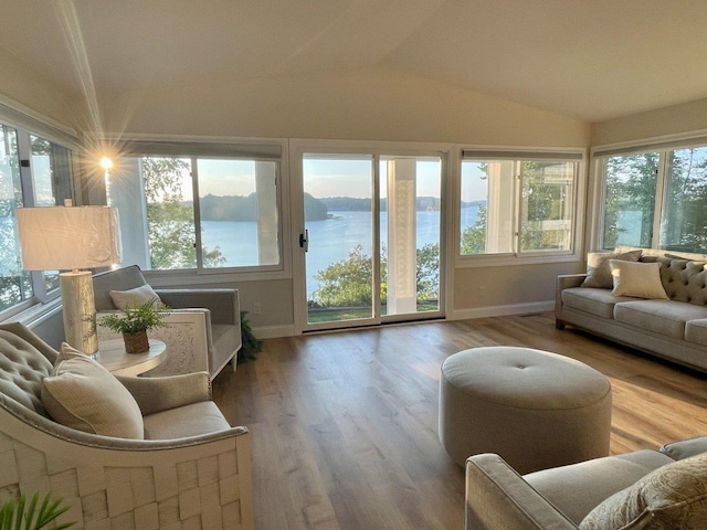 sunroom featuring a water view and vaulted ceiling