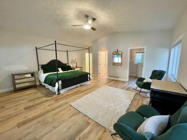 bedroom with lofted ceiling, light wood-type flooring, visible vents, and baseboards