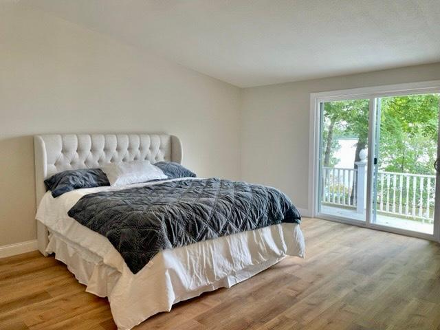 bedroom featuring baseboards, light wood finished floors, and access to exterior