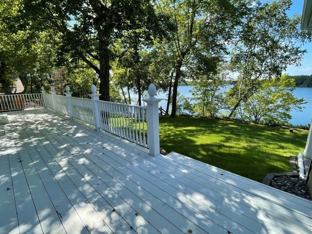 deck with a water view and a lawn