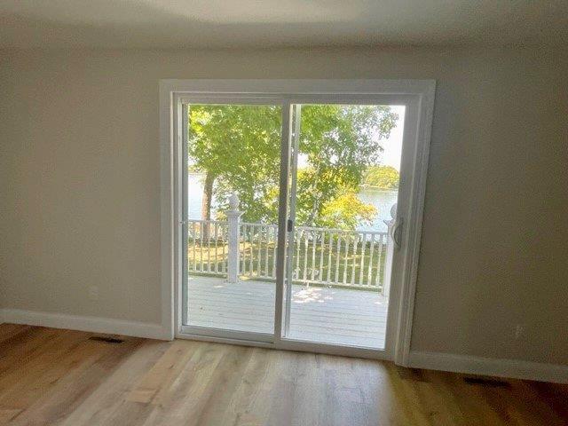 doorway to outside with light wood-style floors and baseboards