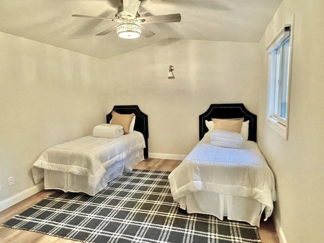 bedroom with lofted ceiling, ceiling fan, wood finished floors, and baseboards