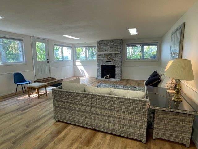 living room with a healthy amount of sunlight, a fireplace, and wood finished floors