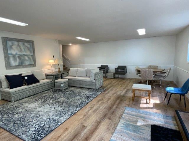 living area with stairway and wood finished floors