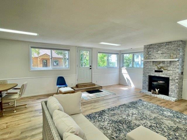 living room featuring a fireplace, a textured ceiling, and wood finished floors