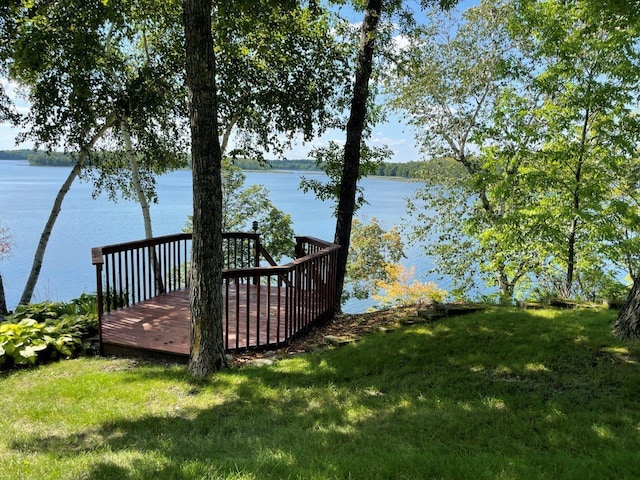 wooden terrace featuring a water view and a yard