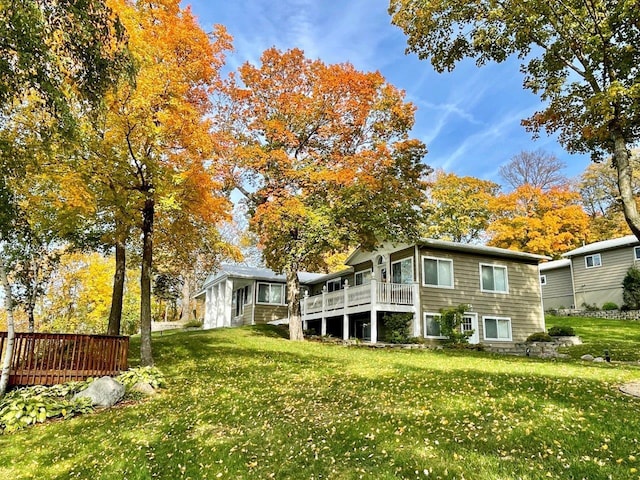 rear view of house with a yard and a wooden deck