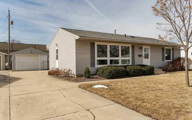 single story home with an outdoor structure, concrete driveway, a garage, and a front yard