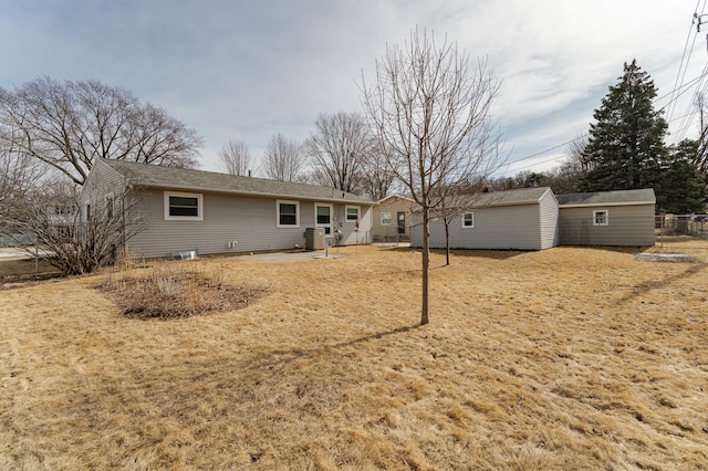 back of property with an outdoor structure and fence