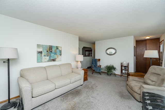 carpeted living area featuring baseboards and a textured ceiling