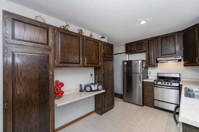 kitchen with under cabinet range hood, dark brown cabinetry, stainless steel appliances, and light countertops