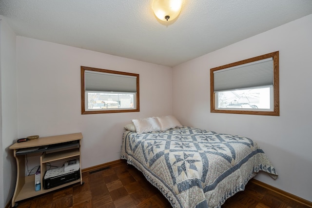 bedroom with visible vents, baseboards, and a textured ceiling