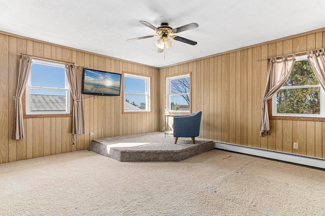 unfurnished room featuring a wealth of natural light, carpet floors, and wooden walls