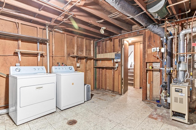 unfinished below grade area with washing machine and clothes dryer, tile patterned floors, and a heating unit