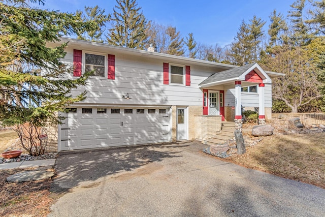 view of front of house featuring brick siding, driveway, and a garage