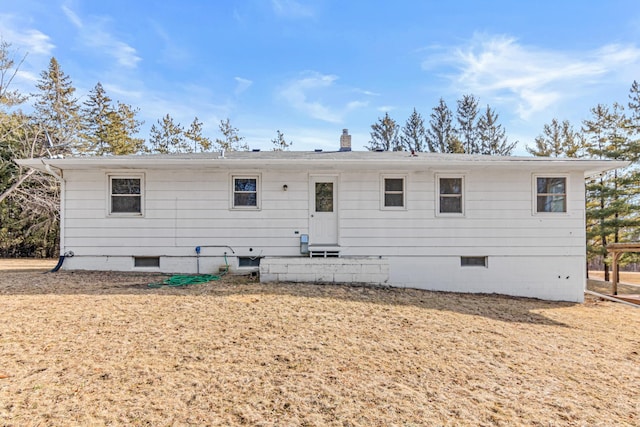 back of property featuring crawl space and a chimney