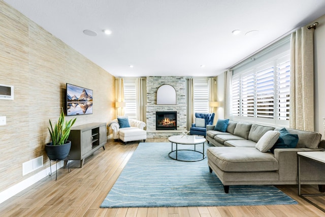 living area with light wood finished floors, a fireplace, visible vents, and recessed lighting