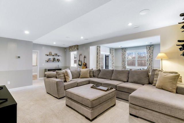 living area with baseboards, recessed lighting, a wealth of natural light, and light colored carpet