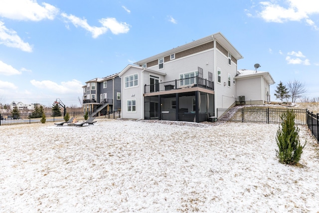 rear view of property with a sunroom, fence, and central air condition unit