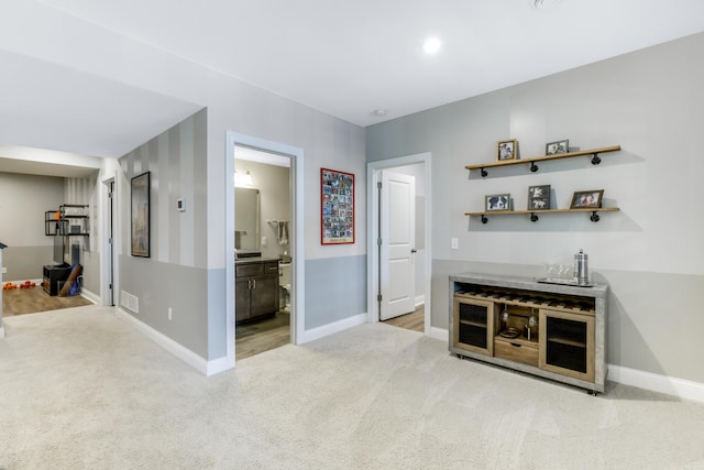 bar featuring visible vents, baseboards, and light colored carpet