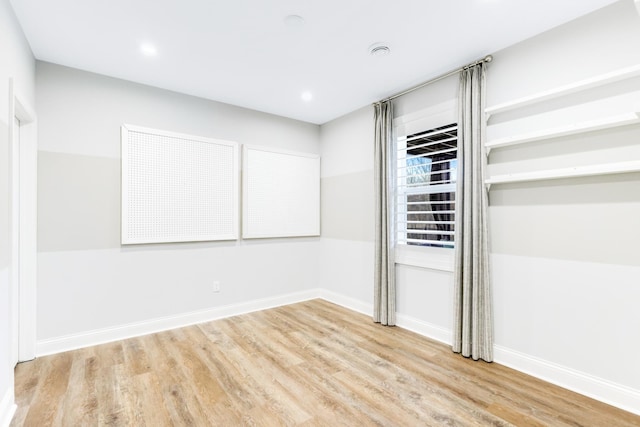 spare room featuring recessed lighting, wood finished floors, and baseboards