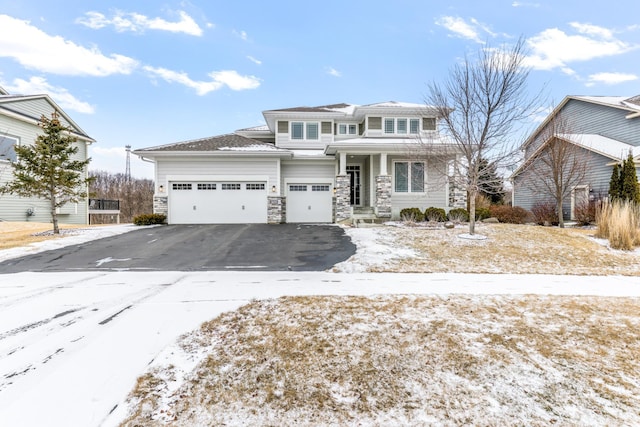 view of front of property with a porch, stone siding, driveway, and a garage