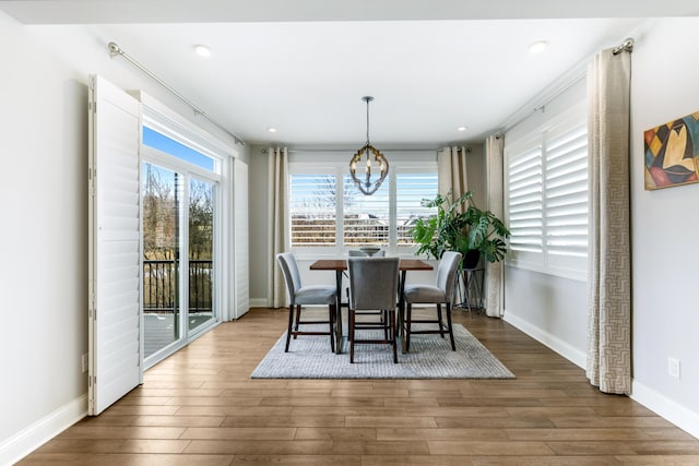 dining room featuring a chandelier, wood finished floors, a wealth of natural light, and baseboards