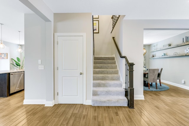 stairway featuring wood finished floors and baseboards