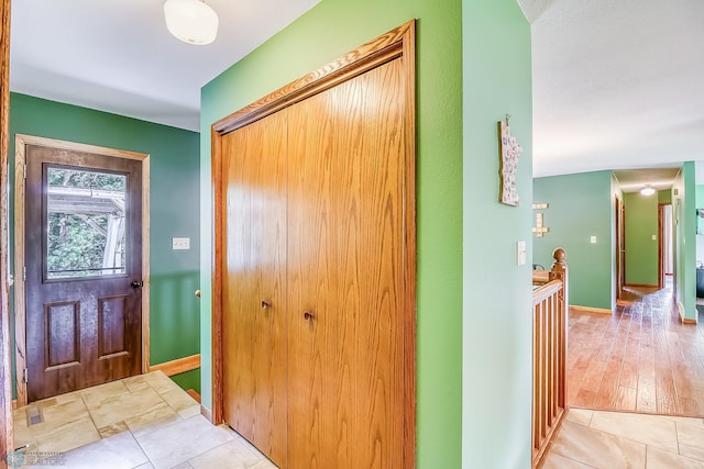 entryway with light tile patterned floors and baseboards