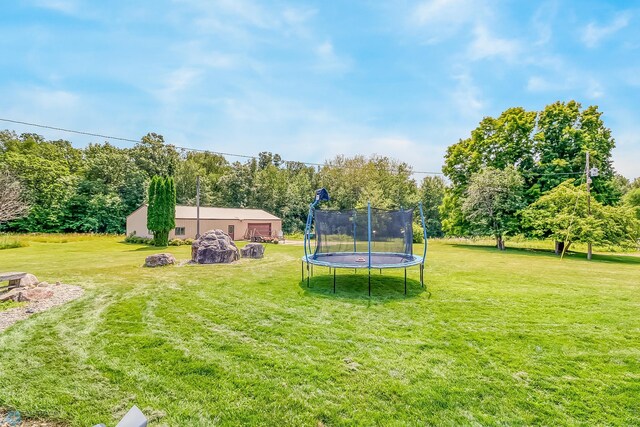 view of yard featuring a garage and a trampoline