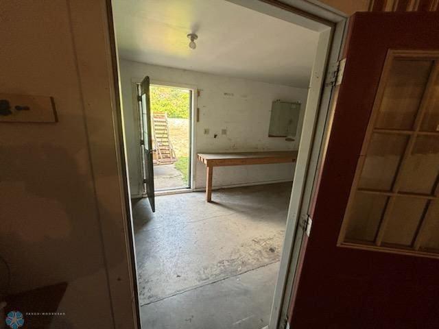 hallway with electric panel and concrete floors