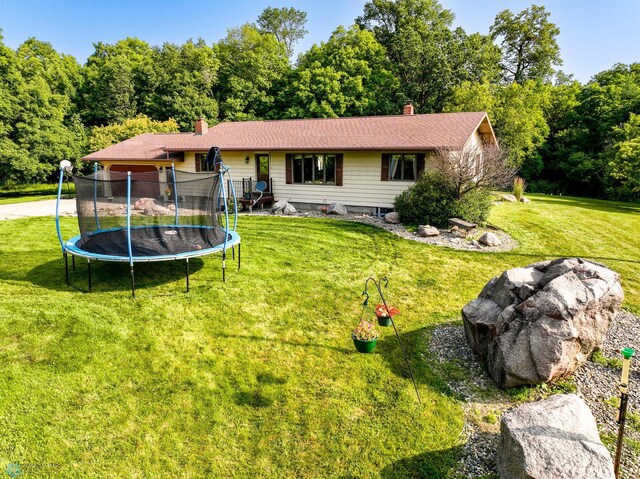 ranch-style home with a trampoline, a chimney, and a front lawn