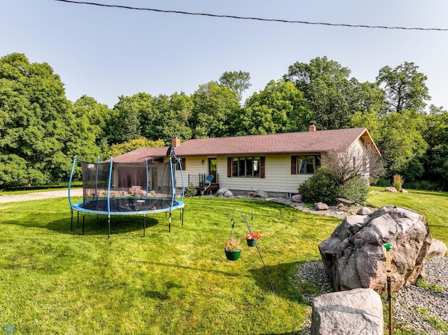 ranch-style home with a trampoline, a chimney, and a front yard