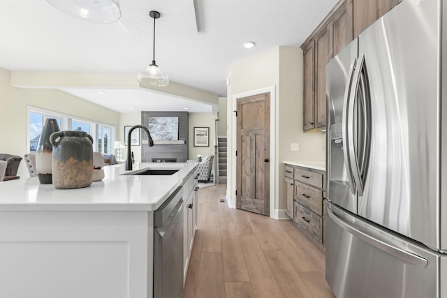 2080 151st Ave NW, Andover, MN 55304 - kitchen featuring stainless steel appliances, a sink, open floor plan, light wood-style flooring, and light countertops