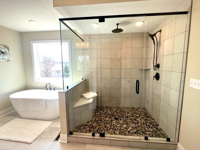 2080 151st Ave NW, Andover, MN 55304 - bathroom featuring a shower stall, a freestanding bath, and baseboards