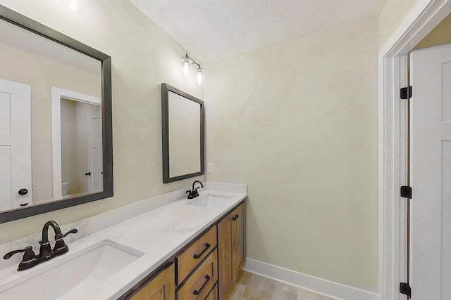 2080 151st Ave NW, Andover, MN 55304 - bathroom with double vanity, toilet, baseboards, and wood finished floors