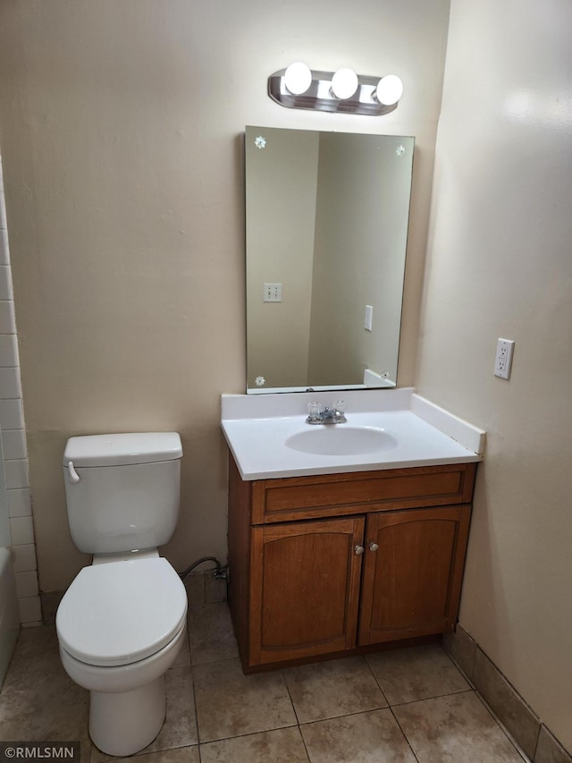 bathroom featuring tile patterned floors, baseboards, toilet, and vanity