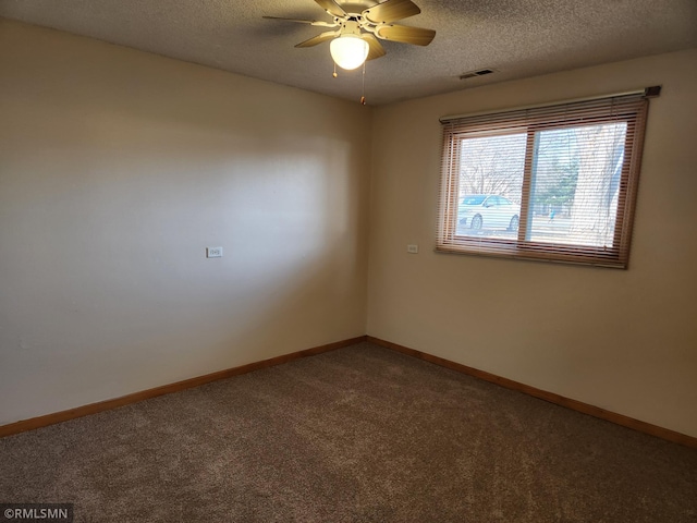 spare room featuring visible vents, ceiling fan, baseboards, carpet floors, and a textured ceiling